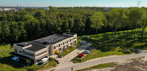 Het Gastenhuisgebouw met daaromheen bomen en gras